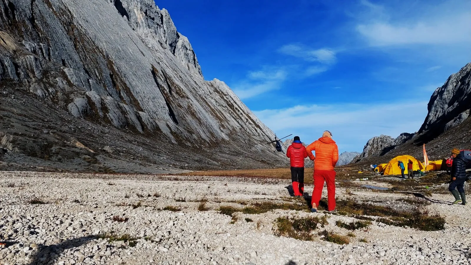 Para pendaki berjalan menuju base camp di bawah dinding batu kapur Carstensz